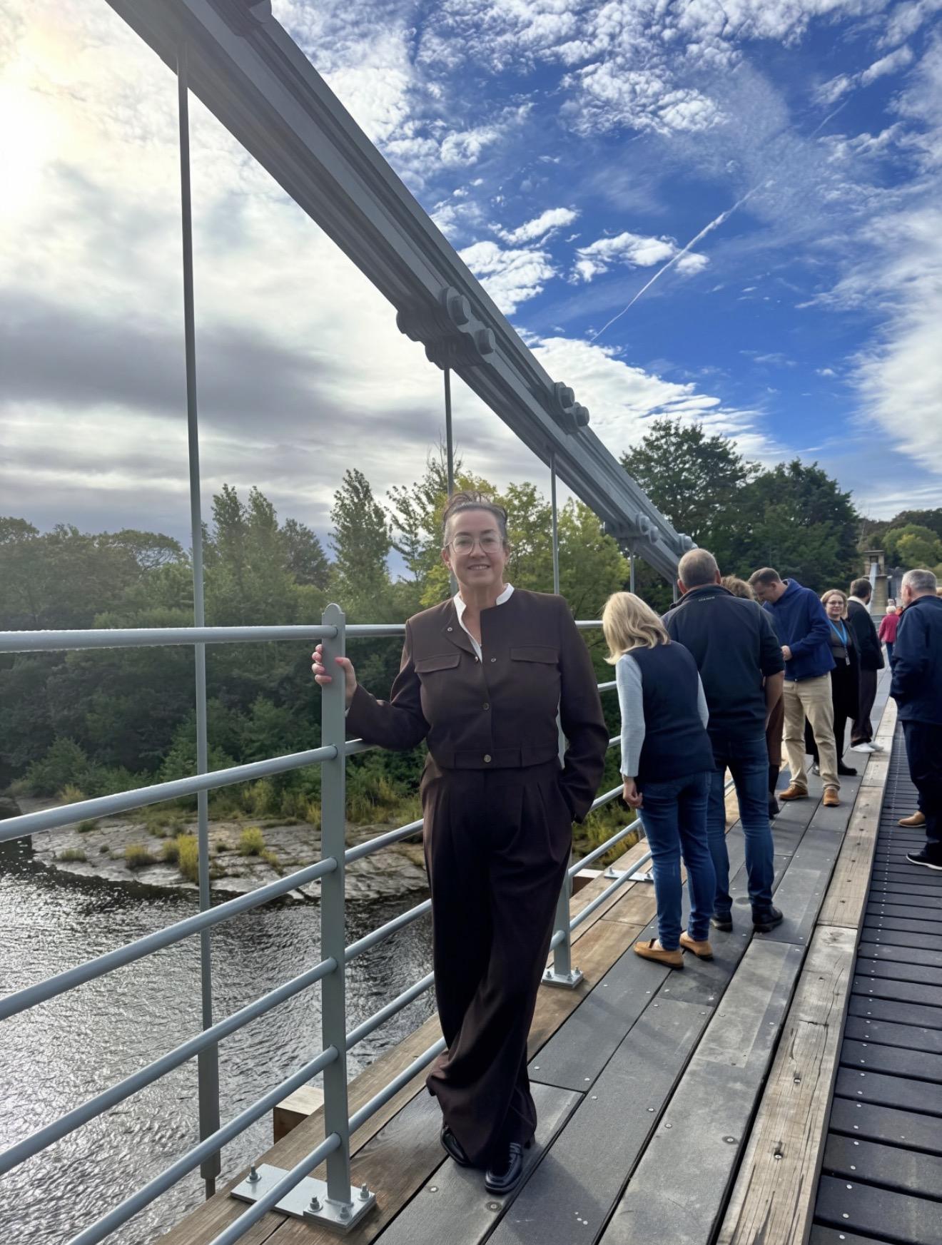 Durham Lifting Managing Director Amanda Gardiner standing on Whorlton Bridge alongside guests during the reopening